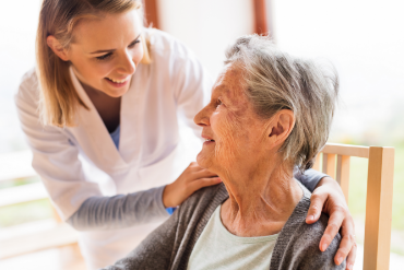 A nurse gently assisting an elderly woman with care and support.