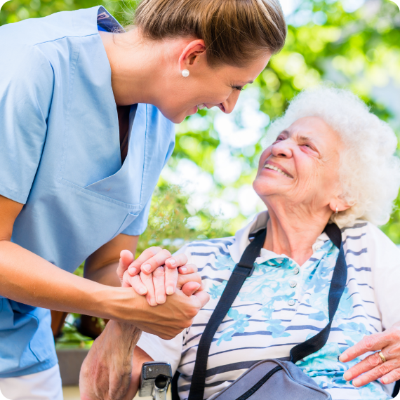 Caring nurse holds elderly woman's hand for comfort