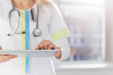 A female doctor confidently uses a tablet to access medical info